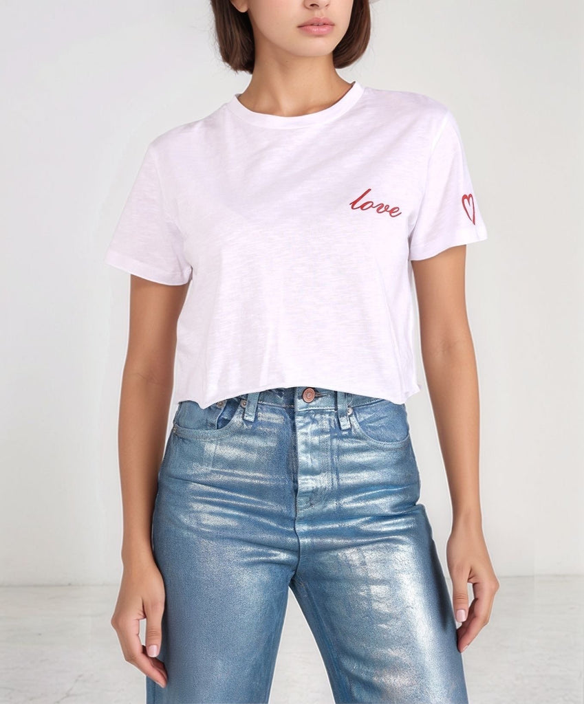 Love T‑shirt – front view of cropped white organic cotton tee with raw-edge hem, styled with Metallic Denim