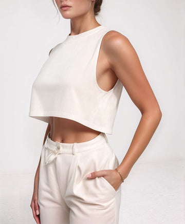 Sila Top – front view of white cropped cotton tank with crew neck, worn with high‑waisted trousers