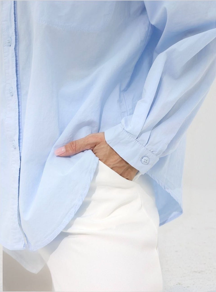 Close‑up of Urban Tranquility Shirt showing cuff and hem detail on light‑blue cotton fabric