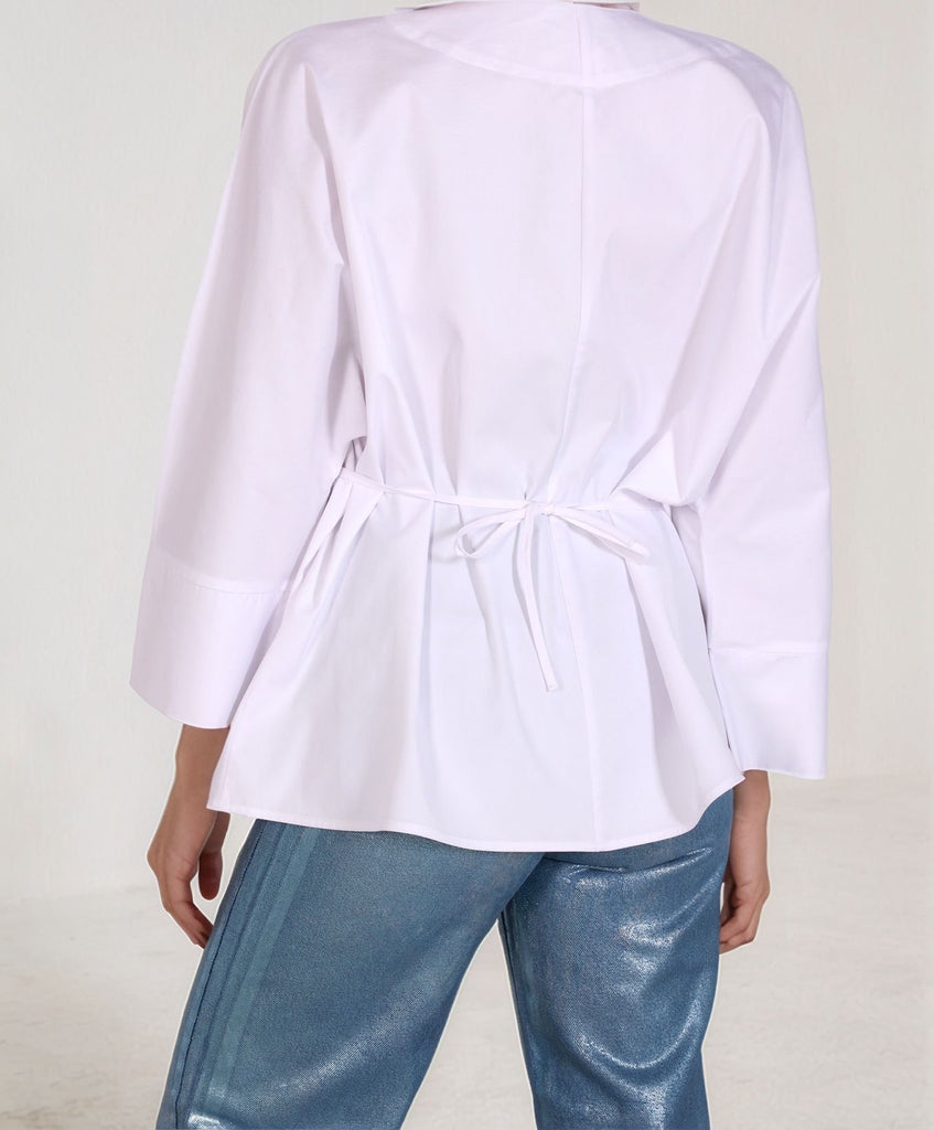 Back view of White Epitome top – relaxed fit and cinched waist detail, paired with metallic denim