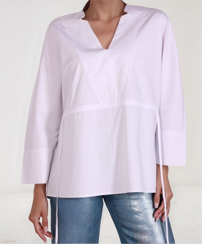Close-up of White Epitome top showing crisp cotton texture and waist cinch detail