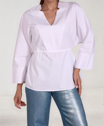 Front view of White Epitome top – waist-tie cotton blend shirt with wide sleeves, styled with metallic denim